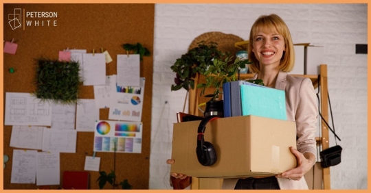 Female employee with box of office supplies